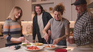 people laughing and preparing lobster in kitchen